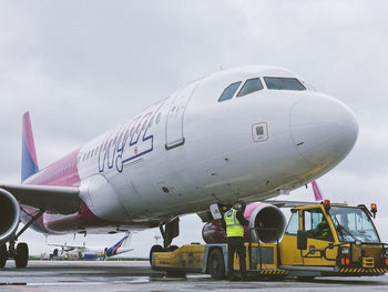 Airplane on airport runway against sky