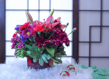 Close-up of red rose on window