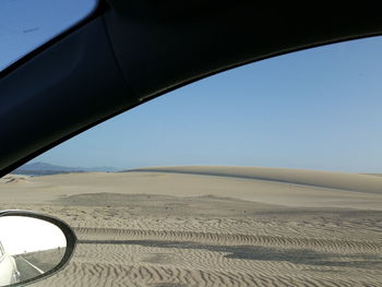 Scenic view of sand dunes against clear sky