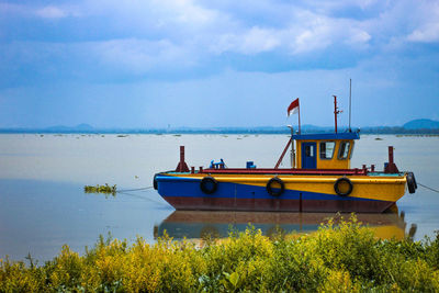 Ship moored in sea against sky