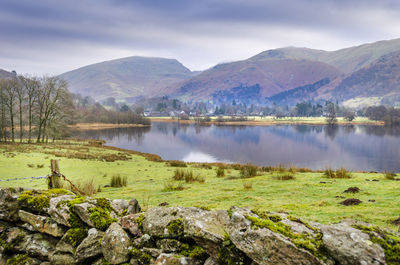 Scenic view of lake by mountains against sky