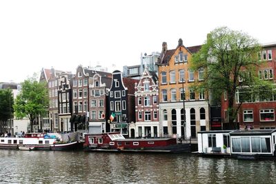 Boats in city against clear sky