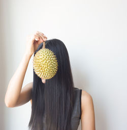 Rear view of woman against white wall