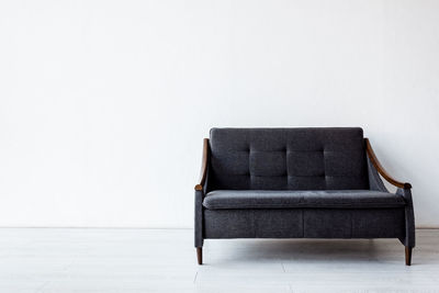 Empty sofa against white wall