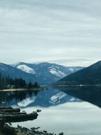 Scenic view of lake by mountains against sky