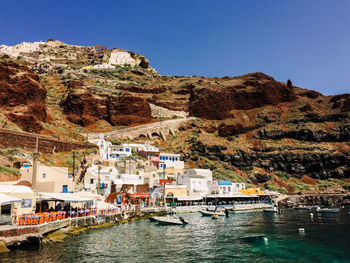 Scenic view of town by mountains against clear sky