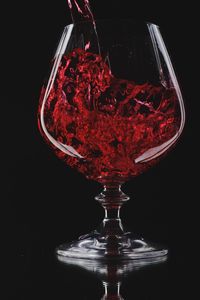 Close-up of wine glass against black background