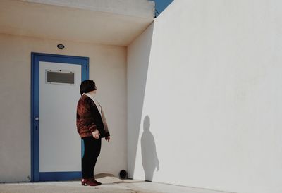 Rear view of woman standing against wall