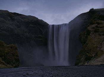 Scenic view of waterfall against sky