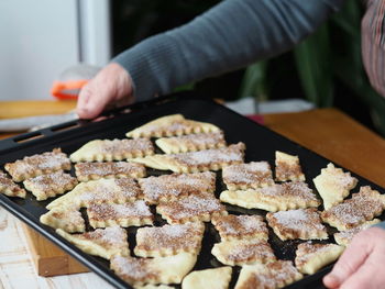 Hands of a woman preparing butter biscuits sprinkled with cinnamon and sugar. homemade food.