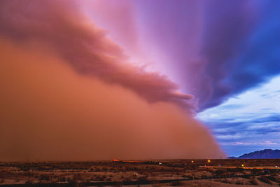 Scenic view of dramatic sky over landscape during sunset