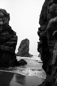 Rock formations on beach against clear sky