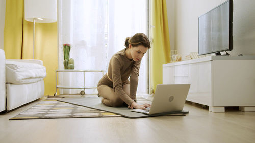 Woman using phone while sitting at home