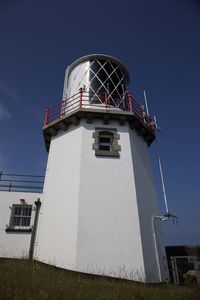 Low angle view of lighthouse against building