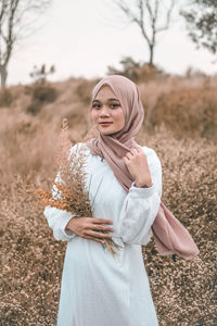 Young woman wearing mask standing on field