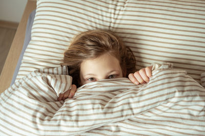 Portrait of girl lying on bed at home