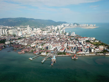 High angle view of city by sea against sky