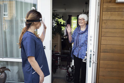 Nurse greeting woman at house