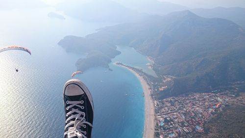 Low section of person by sea against sky