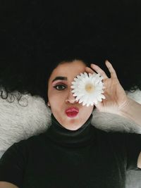 Portrait of beautiful woman with white flower in sunlight