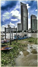 Buildings in city against cloudy sky