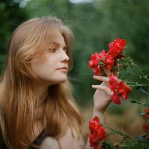 Close-up of woman with red flowers