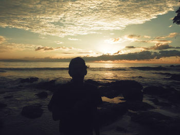 Rear view of silhouette man standing on beach