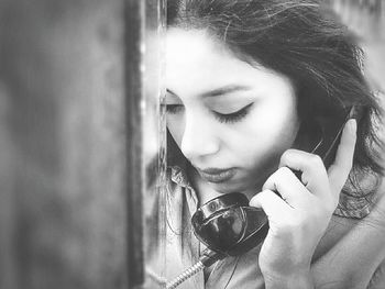 Close-up of woman holding telephone and looking down