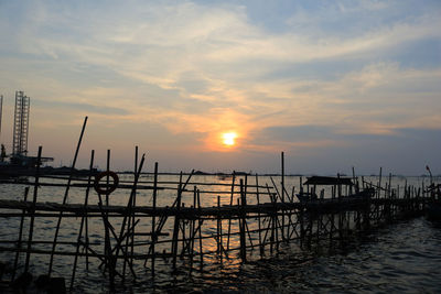 Pier over sea against sky during sunset