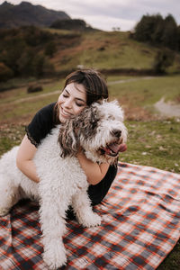 Portrait of woman with dog on field