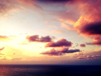 Scenic view of sea against cloudy sky at sunset