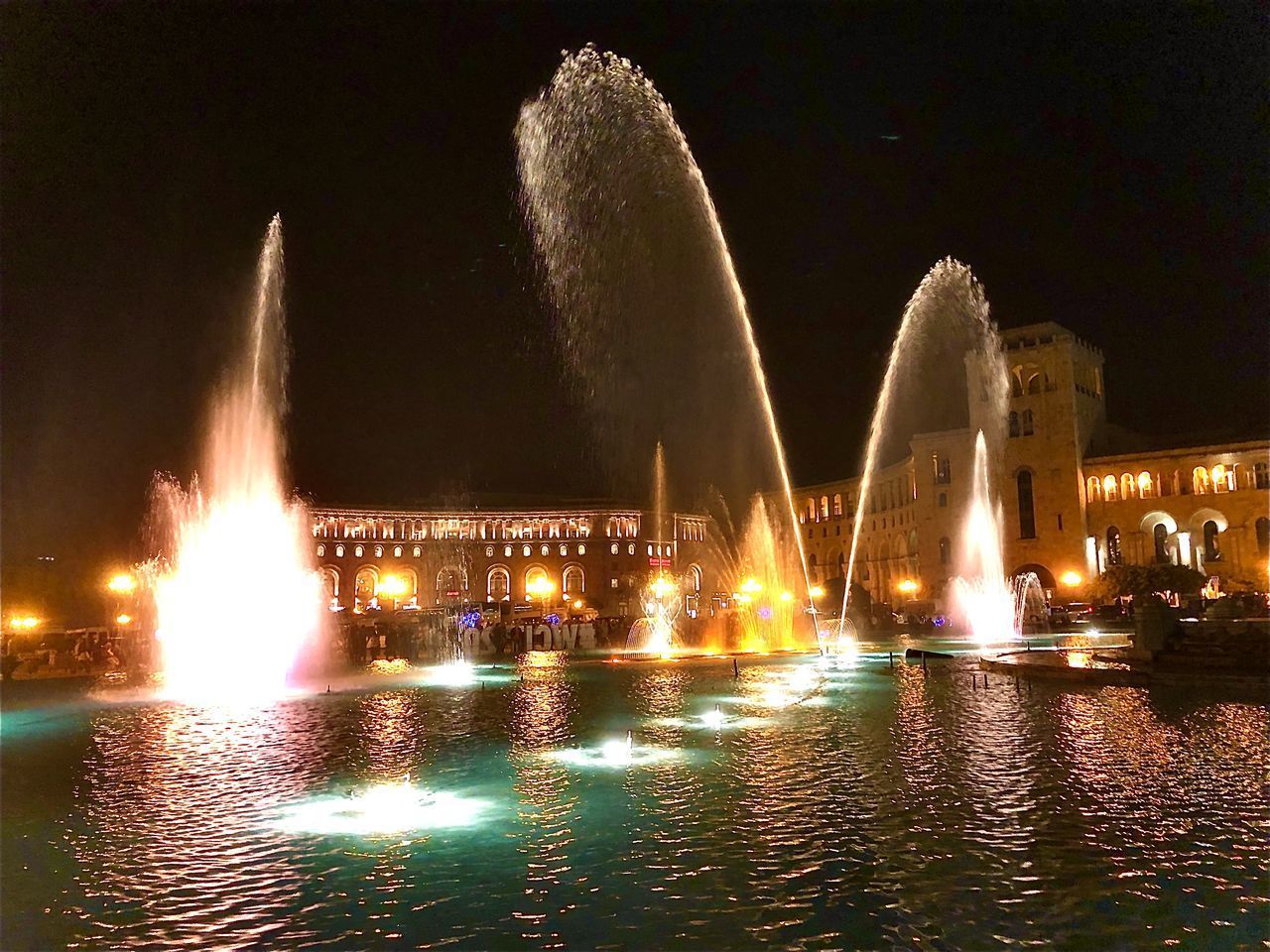 VIEW OF ILLUMINATED CITY AT NIGHT