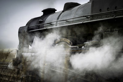 Smoke emitting from train against sky
