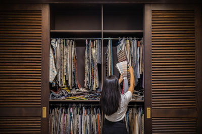 Rear view of businesswoman comparing fabrics