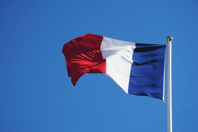 Low angle view of french flag against clear blue sky