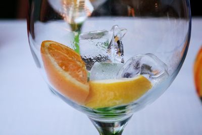 Close-up of fruits and ice cubes in glass on table