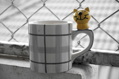 Close-up of coffee cup on window sill