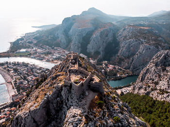 Aerial view of rock formation and pirate castle overlooking valley in omis, croatia. 