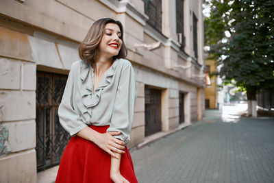Young woman standing against wall