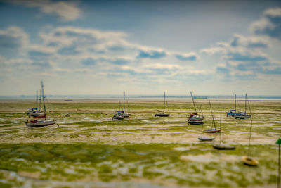 Tilt-shift image of boats on shore against sky