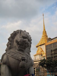 Low angle view of statue of temple against cloudy sky