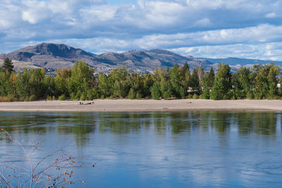 Scenic view of lake by trees against sky