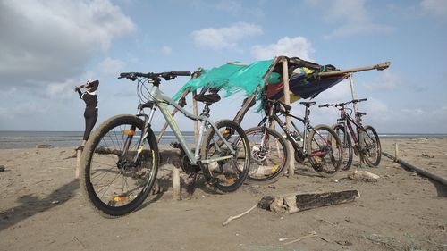 Bicycles on beach against sky