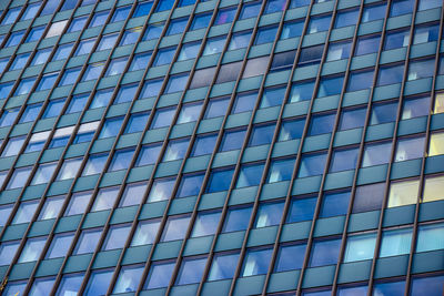 Low angle view of glass building against sky