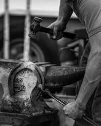 Cropped image of blacksmith shaping horseshoe in industry