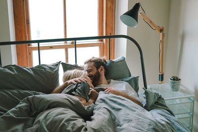 Young couple relaxing on bed at home
