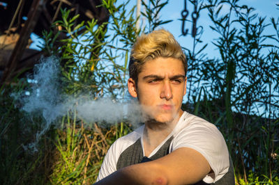 Portrait of young man against trees