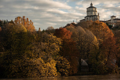 Trees and building against sky during autumn