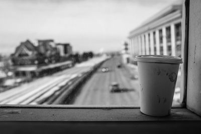 Close-up of disposable cup on window sill