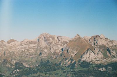 Scenic view of snowcapped mountains against clear blue sky